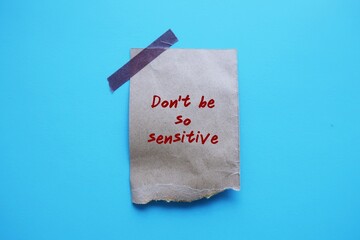 Torn paper stick on blue background with handwriting Don't Be So Sensitive, gaslighting message to accuse or emotional abuse others to question their beliefs or doubt perceptions and become distressed