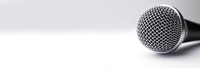 Top view of black microphone on dark background and empty space for text for website. Long web banner.Top view,Long banner format