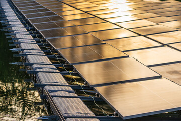 Side view of solar panels floating on water in a lake, for generating electricity from sunlight.