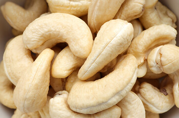 Close up of Fresh tasty cashew nuts in bowl on white background. Top view