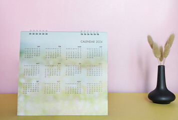 Calendar year 2024 schedule , 12 months desk calendar 2024 and alarm clock decoration on the table....