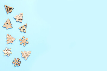 Wooden Christmas tree and wooden snowflake on light blue background. New year symbol, Christmas tree.