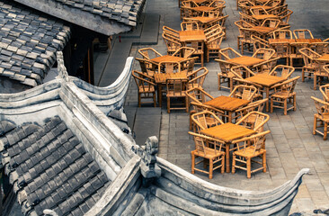 empty tables and chairs under traditional Chinese roof