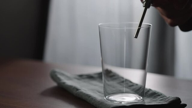 Slow motion pour nitro coffe in tumbler glass on wood table
