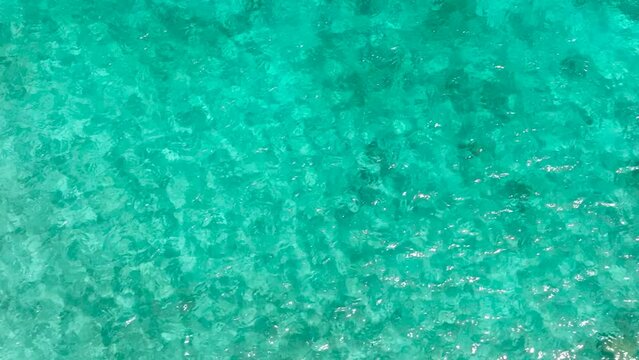 Sea surface with turquoise water and sun reflection. Mantigue Island. Camiguin, Philippines.
