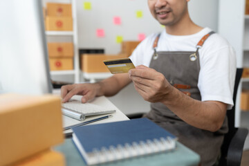 online shopping order concept Man holding credit card and using pc for shopping at home To register a credit card on a computer to create secure electronic payments online.