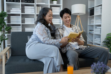 family holidays, hobbies Image of two couples, mother and son doing activities together. Reading books, tablets, talking, giving advice, resting, drinking orange juice to relax in the office in house