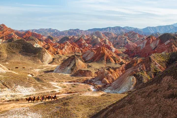 Papier Peint photo Zhangye Danxia Travellers on camels in Colorful mountain in Danxia landform in Zhangye, Gansu of China. Silk road landscape, copy space for text, sunset picture