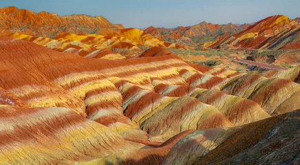 Fototapete Zhangye-Danxia The road through the typical Danxia land form in Zhangye Danxia Geological Park, Zhangye, Gansu, China. Blue sky with copy space for text, colorful, panorama