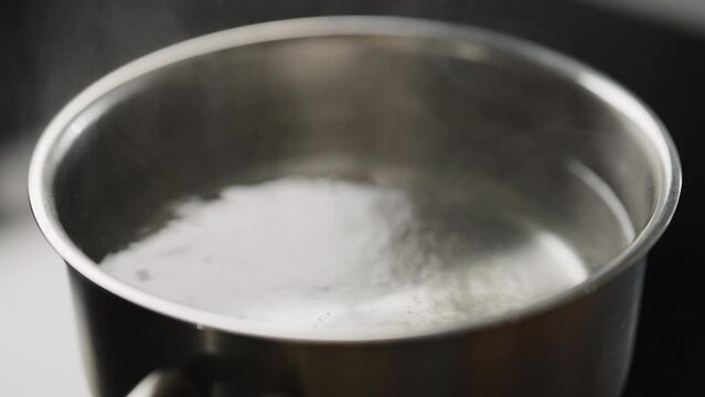 Slow motion boling water in saucepan