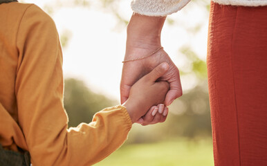 Mother, kid and holding hands for walking in park for support, trust and care together or bonding in nature. Love, comfort and parent help child in the morning sunshine with kindness on weekend - obrazy, fototapety, plakaty