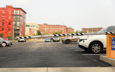 parking lot gate, a barrier depicting control, access restriction, transition, and urban confinement