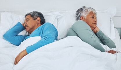 Sleeping, fighting and a senior couple in a bed with insomnia in a marriage together. Conflict, tired and elderly man and woman in the bedroom for rest in divorce and a nap with thinking in a house