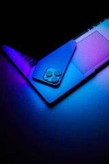 Laptop with smartphone. Neon dark light. - 639772379