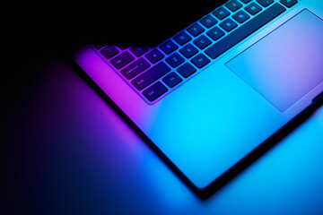 Close up image of laptop in dark neon light. - 639772535