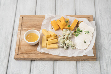 Cheese plate with grapes and nuts on wooden table