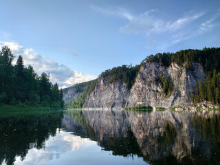Fototapeta premium Landscape with the image of a mountain lake in the forest. The picturesque cliffs on the river bank