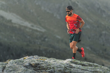 An athlete runs over boulders in the mountains