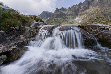 Fototapeta na wymiar Beautiful alpine landscape with foreground waterfall and background rocky peaks, Slovakia, Europe