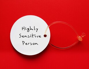 Tag on red background with handwritten text HIGHLY SENSITIVE PERSON, refers to people who think and feel everything more deeply, more sensitive to the environment and social interactions - obrazy, fototapety, plakaty