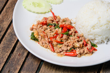 Stir fried Thai basil with minced pork on the wooden background. Favorite food of Thailand 