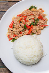Stir fried Thai basil with minced pork on the wooden background. Favorite food of Thailand 
