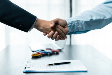 Sale woman or businesswoman shaking hands with female after car loan agreement was signed.