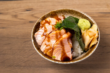 Top view Grilled Salmon Don and sauce. Japanese food on restaurant table. Isolate on wood background
