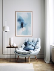 Blue snuggle chair against white wall with art poster frame and pendant light. Mid century style interior design of modern living room