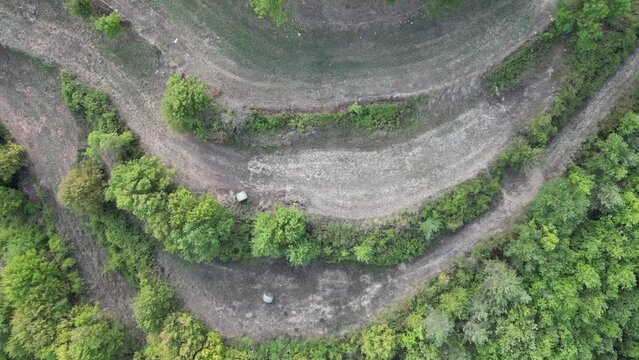 Aerial footage of a chapel and cementery in the middle of the forest.