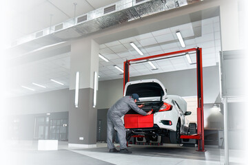 Panorama of car service. Mechanic repairing a car. Horizontal photo of car repair in the dealership.