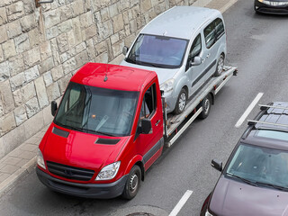 A tow truck on the public road. Tow truck with broken car on country road. Tow truck transporting...