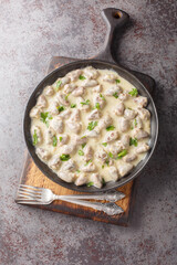 Home cooked chicken hearts in garlic creamy sauce close-up in a plate on the table. Vertical top view from above