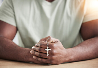 Crucifix cross, man hands and prayer beads in home with faith, christian praise and religion. Praying, necklace and worship in house with hope, gratitude and spiritual guide for support and healing