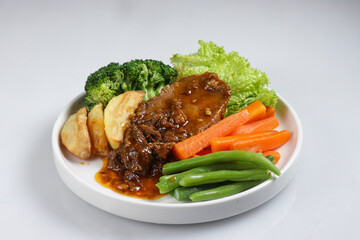 Bistik Lidah Sapi or Tounge Beef Steak Served with Barbecue Sauce and Vegetables.