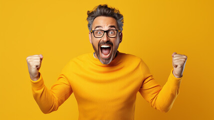 Cheerful and excited adult man wearing yellow shirt celebrating success.