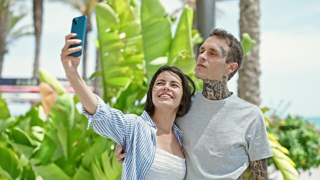 Beautiful couple hugging each other make selfie by smartphone at park