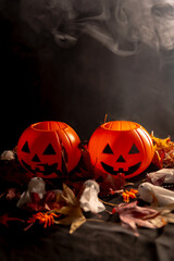 Halloween pumpkins over autumn leaves and ghosts with smoke on a black background, copy paste space
