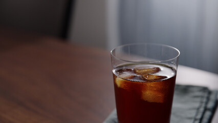 Slow motion man making iced coffee with filter coffee in glass on wood table