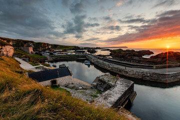 Fototapeta premium Stunning Summer Sunset at the Ballintoy Harbour, Antrim, Northern Ireland 