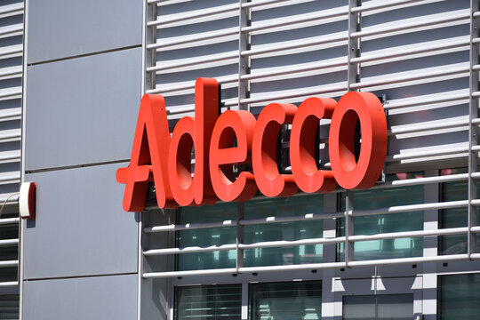 Adecco recruitment company signage, logo on the office facade. WARSAW, POLAND - JUNE 3, 2023