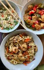 Aarroz, pollo con verduras y tallarines con gambas, platos típicos de la comida china 