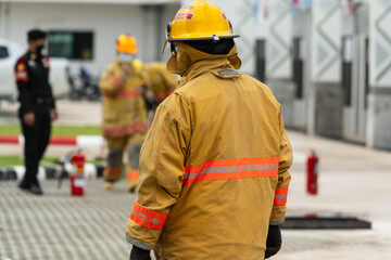 Firefighter working on the fire site.Fireman protection suit uniform for ready working.Rescue doing teamwork against fire.Firemen fighting fire during training for employees industry.