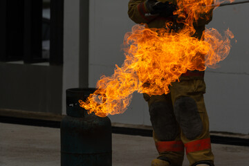 Showing how to use a fire extinguisher on a training fire for employees industry.Firefighter...