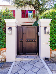 A luxury house entrance dark charcoal painted iron door by the sidewalk. Travel to Athens, Greece.