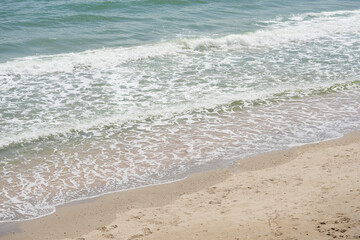 Fototapeta na wymiar Aerial view of sea waves, sandy beach.
