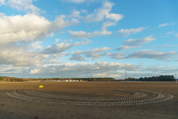 Obraz premium The background is a plowed field and beautiful clouds. Deep furrows in the ground after tractor work with a plow. Plowing the ground. the treatment of the topsoil to saturate the soil with oxygen