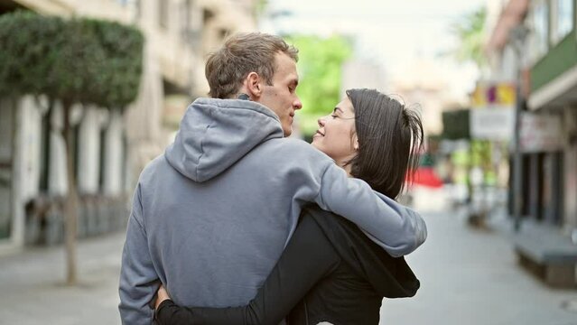 Beautiful couple hugging each other kissing at street