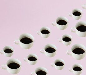 A pattern made of coffee cups in different sizes on a pastel purple background. Copy space. Creative pattern. Minimal concept.