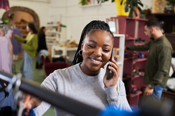 Shopping, woman and phone call for talking fashion at a retail store with sale or discount. Black person or happy customer on smartphone for product choice, promotion or communication in a boutique